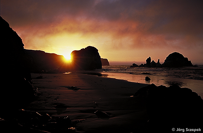 Die im Schatten liegenden großen Felsformationen am Sand Dollar Beach vor dem Gegenlicht des Sonnenuntergangs