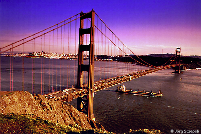 Blick von Battery Spencer auf die diagonal durchs Bild verlaufende Golden Gate Bridge bei Sonnenuntergang