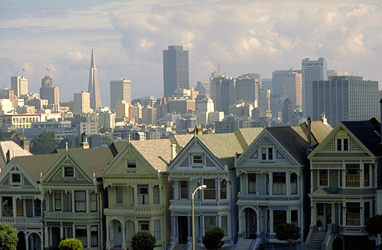 Blick über die weltbekannten sechs viktorianischen Holzhäuser am Alamo Square Park auf San Franciscos´ Zentrum